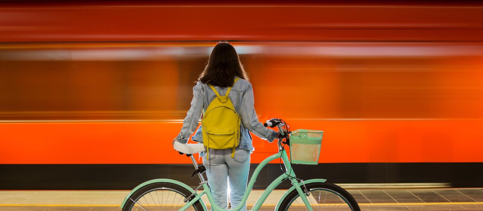 Woman with a bicycle at a train station